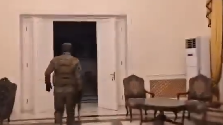 A HTS jihadist walks inside the Presidential Guest Palace in Aleppo, Syria, December 1, 2024